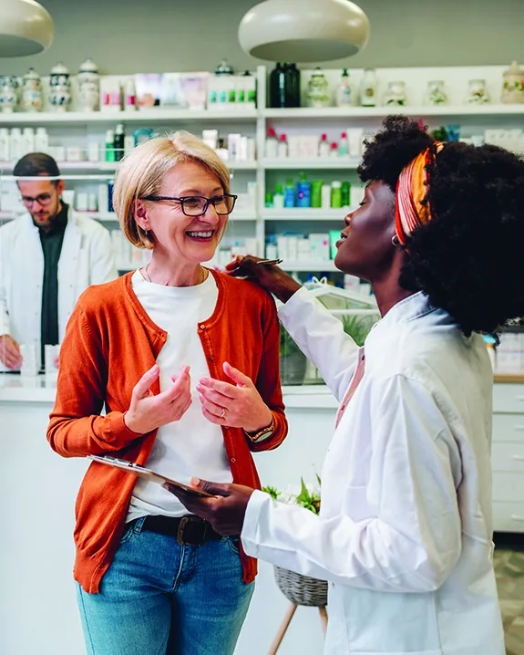 A pharmacist talking with a patient at the counter